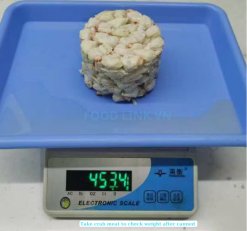 Weight checking canned swimming crab meat before sealing in Vietnam