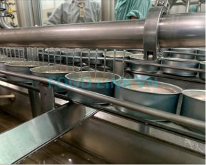 Pouring liquid into canned tuna during production